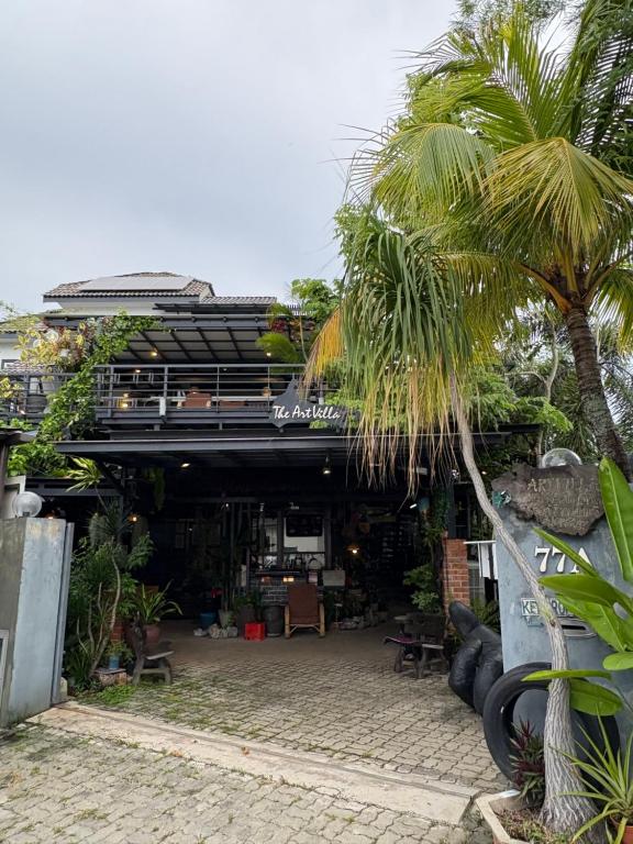 a building with a palm tree in front of it at Art Villa in Alor Setar