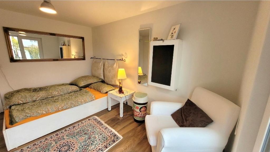 a small bedroom with a bed and a chair at Charmante Waldrandidylle in Kreuzlingen