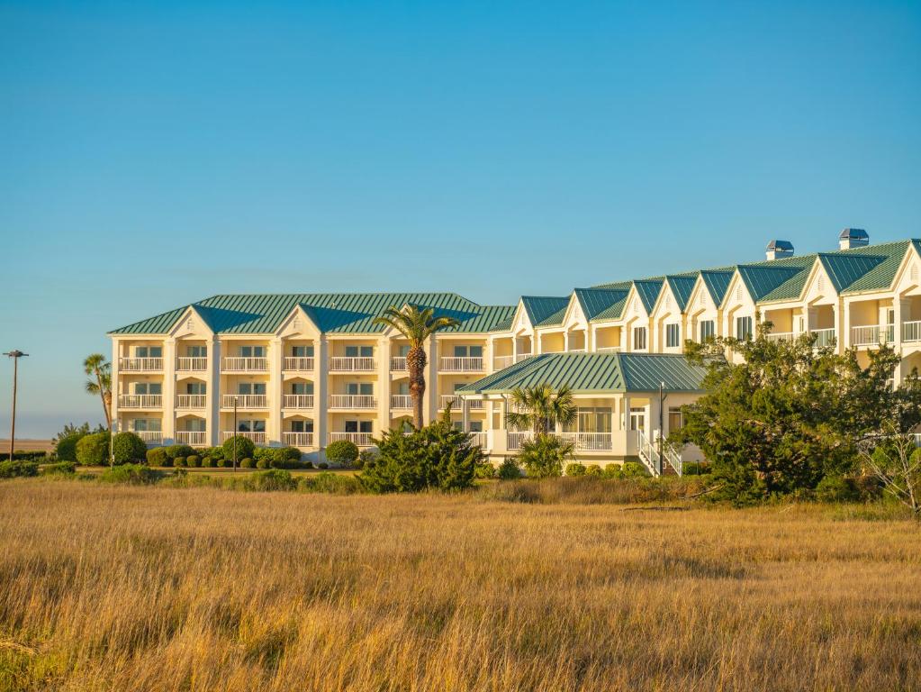 a large resort building with a field in the foreground at Epworth By The Sea in Saint Simons Island