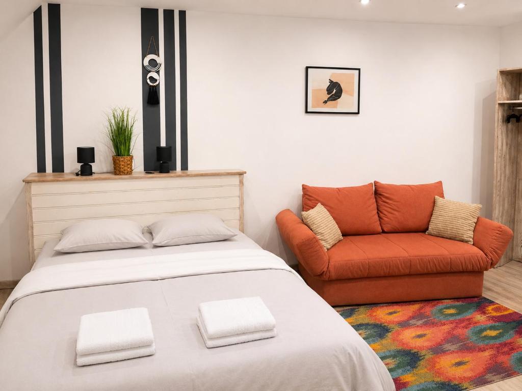 a bedroom with a bed and a couch at Luna Apartman in Eger