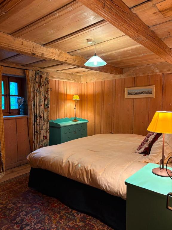 a bedroom with a bed in a room with wooden walls at Chalet de montagne sur le TMB in La Fouly
