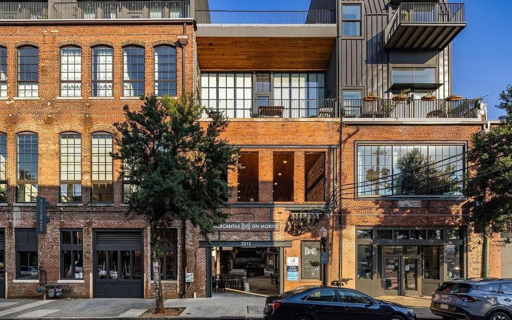 a brick building with cars parked in front of it at Stylish Birmingham Loft + Rooftop Lounge in Birmingham