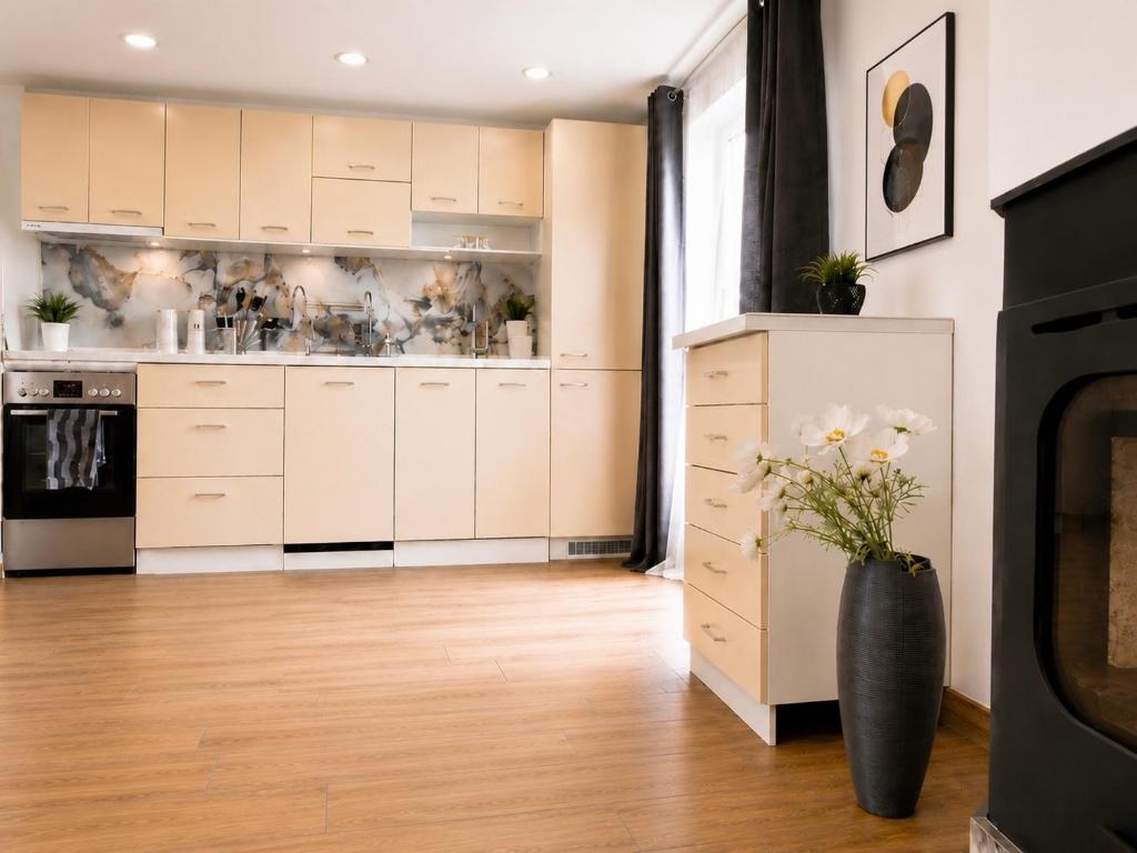 a kitchen with white cabinets and a vase of flowers at Victoria Elegance Apartment in Sofia