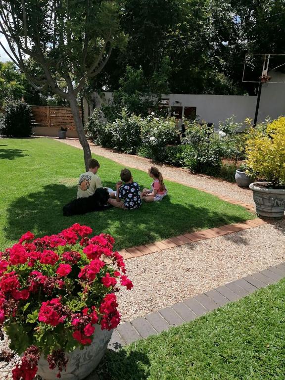 two children sitting on the grass in a garden at Ormonde guesthouse in Pretoria