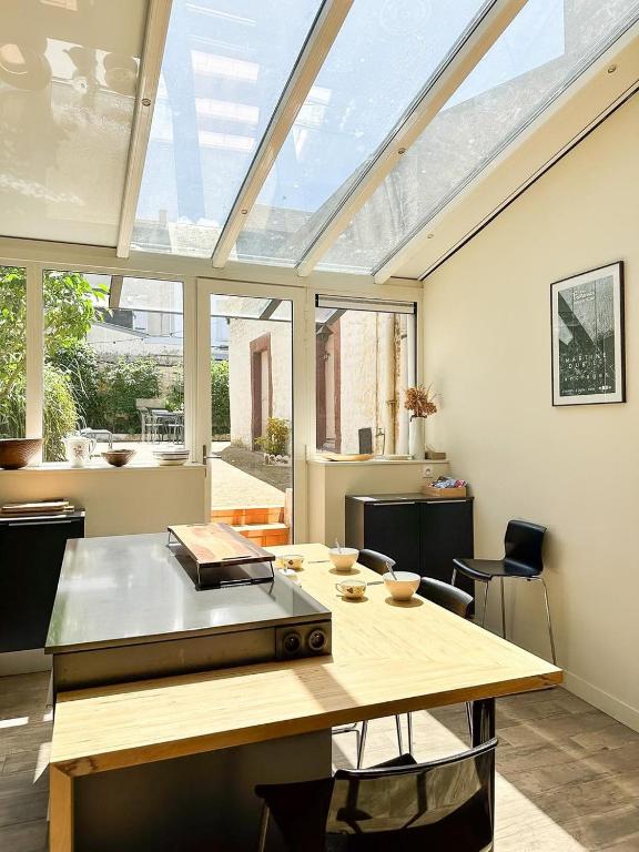 a kitchen with a table and a large window at Les Soupières in Fécamp