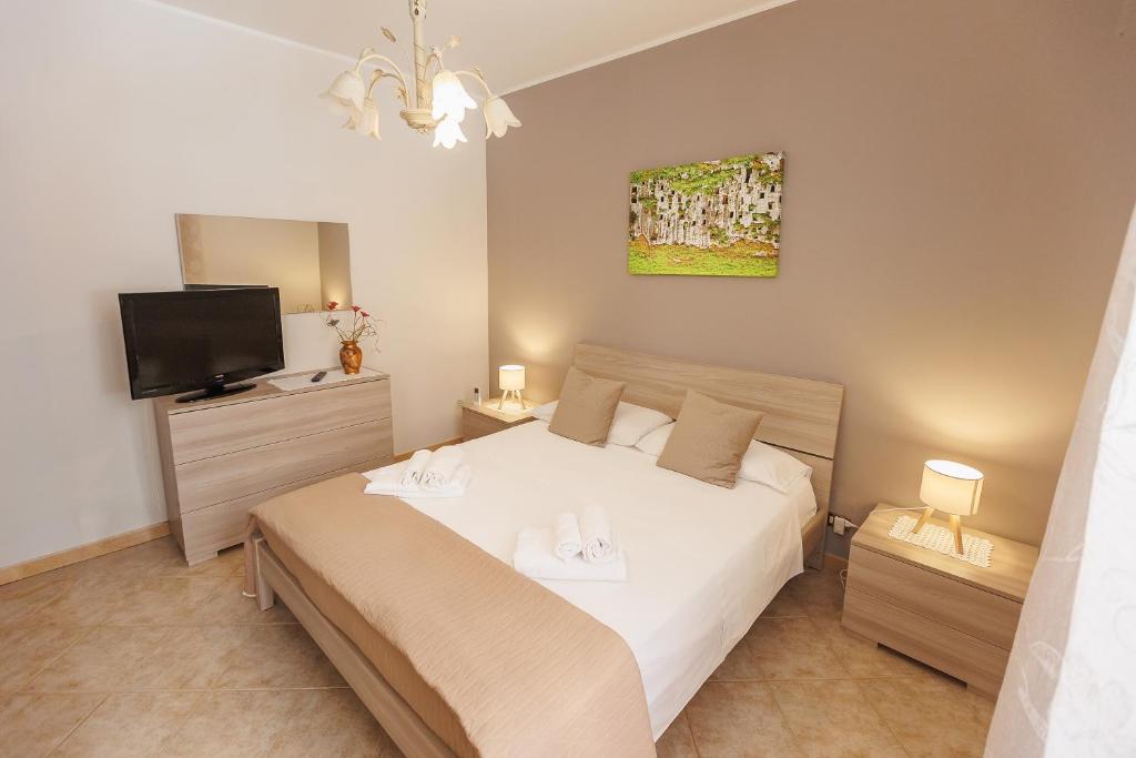 a bedroom with a bed and a flat screen tv at Casa Lina - 10 minuti da Pantalica-parcheggio gratuito in Sortino