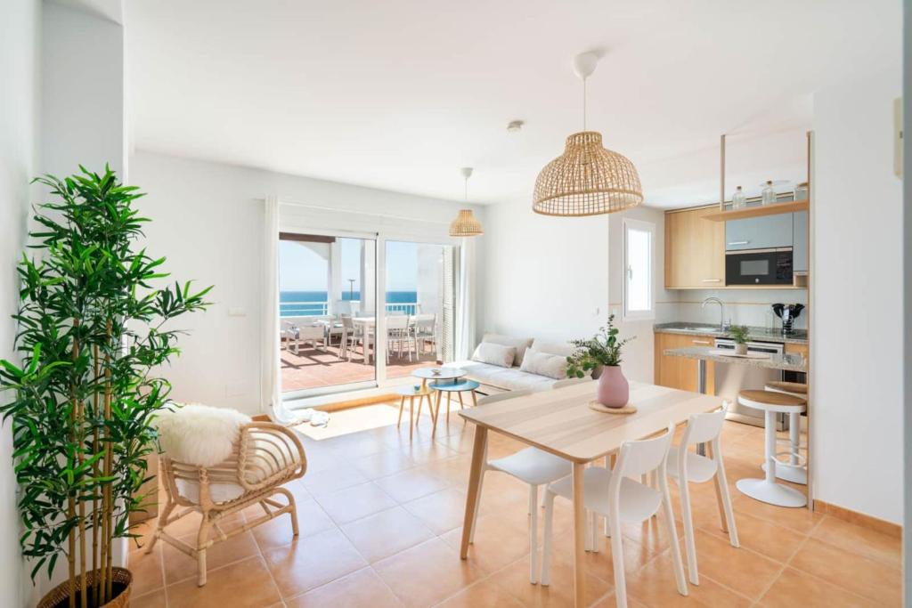 a kitchen and living room with a table and chairs at MarLau Breeze in Mojácar