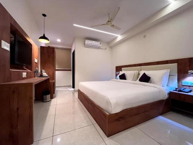 a bedroom with a large bed and a television at Hotel LIORA GRAND in Bangalore