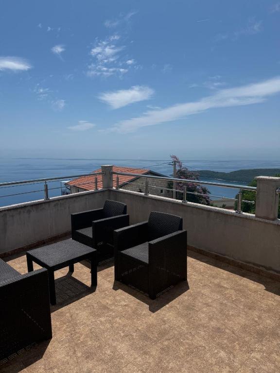 a patio with chairs and tables on a balcony at Villa Panoramic Sea View in Seoca