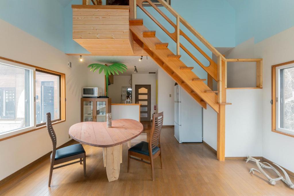 a kitchen and dining room with a wooden table and stairs at Kussharoko Artemina Deer in Teshikaga