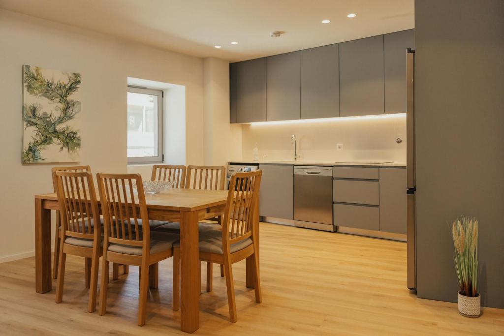 a kitchen and dining room with a table and chairs at Gerês Thermal Escape in Geres