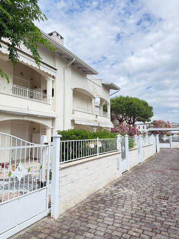 a white fence in front of a house at Appartamento ELDORADO in Lido di Pomposa