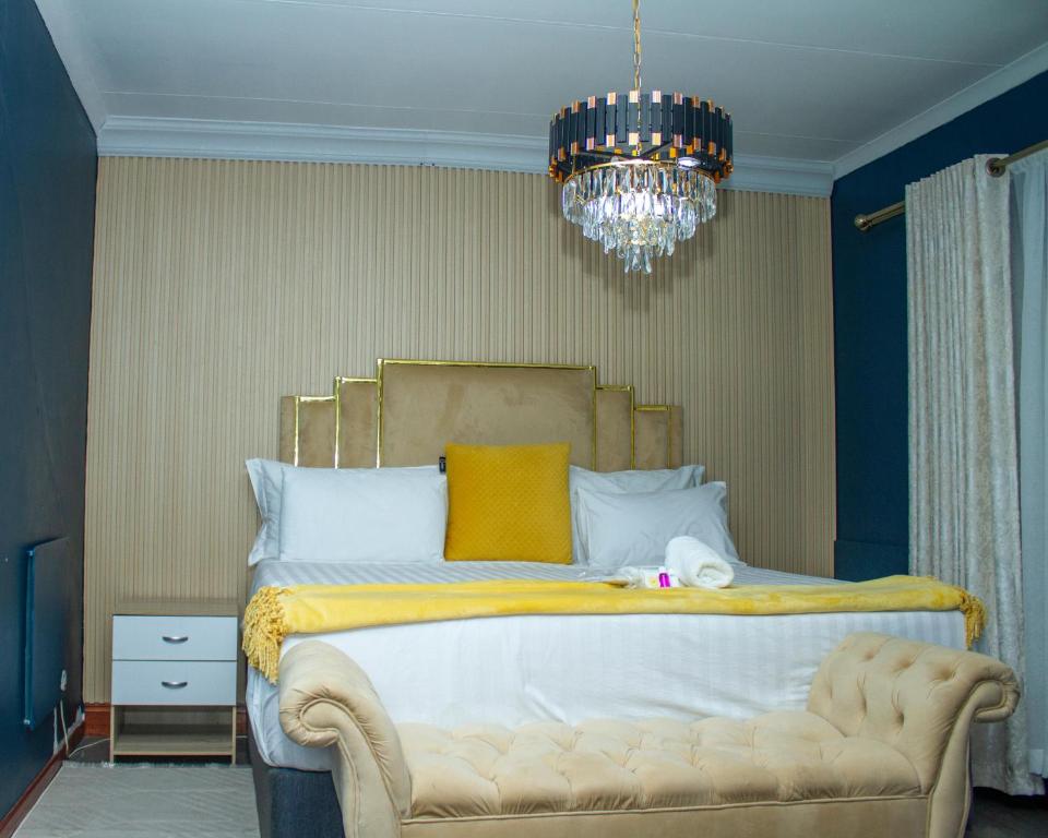 a bedroom with a large bed with a chandelier at Kariebi Guest House in Bethlehem