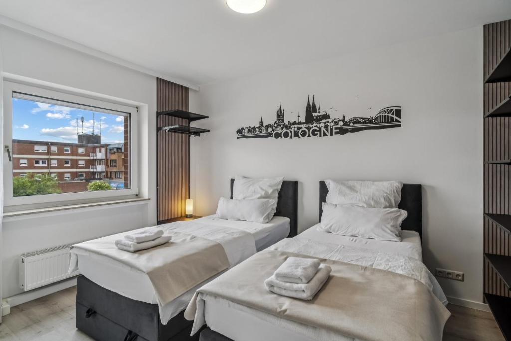 zwei Betten in einem Zimmer mit Fenster in der Unterkunft Villa Cologne - Apartments & Monteursquartiere in Meckenheim bei Köln in Meckenheim