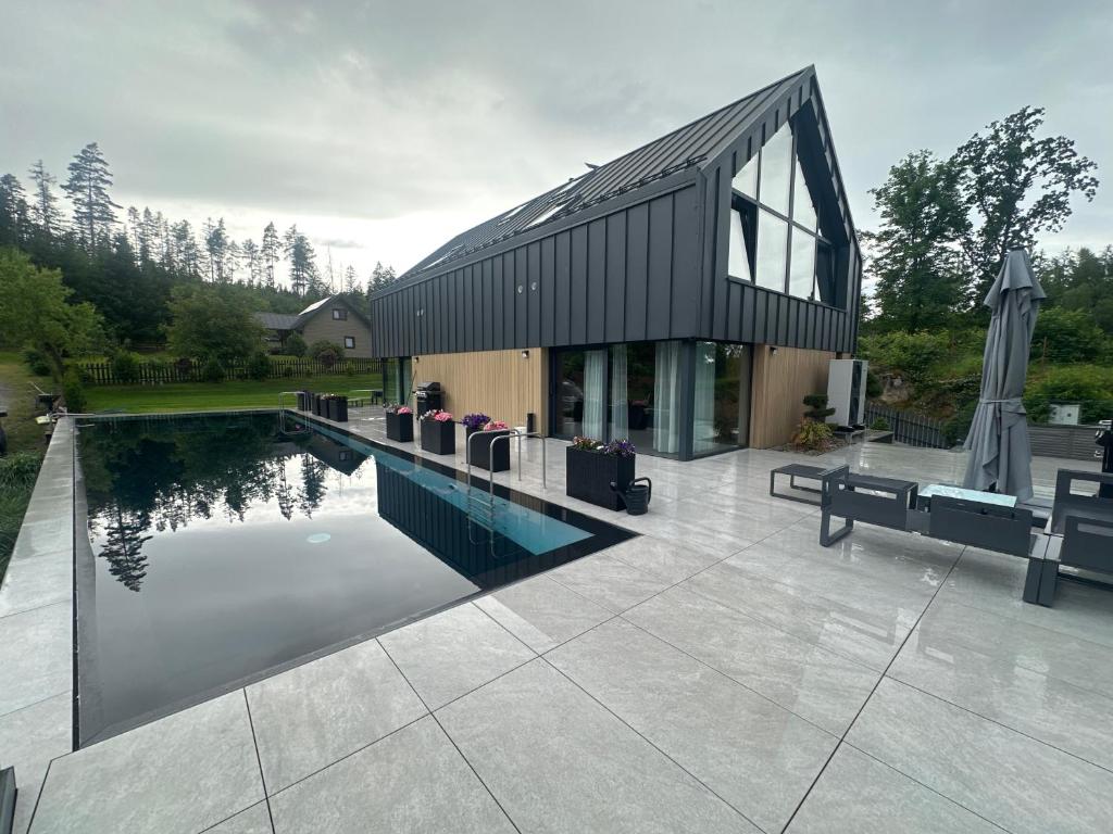 a house with a swimming pool in front of a house at Dom w Czerwonej Dolinie Haus im Roten Tal Seidorf Sosnówka` in Sosnówka