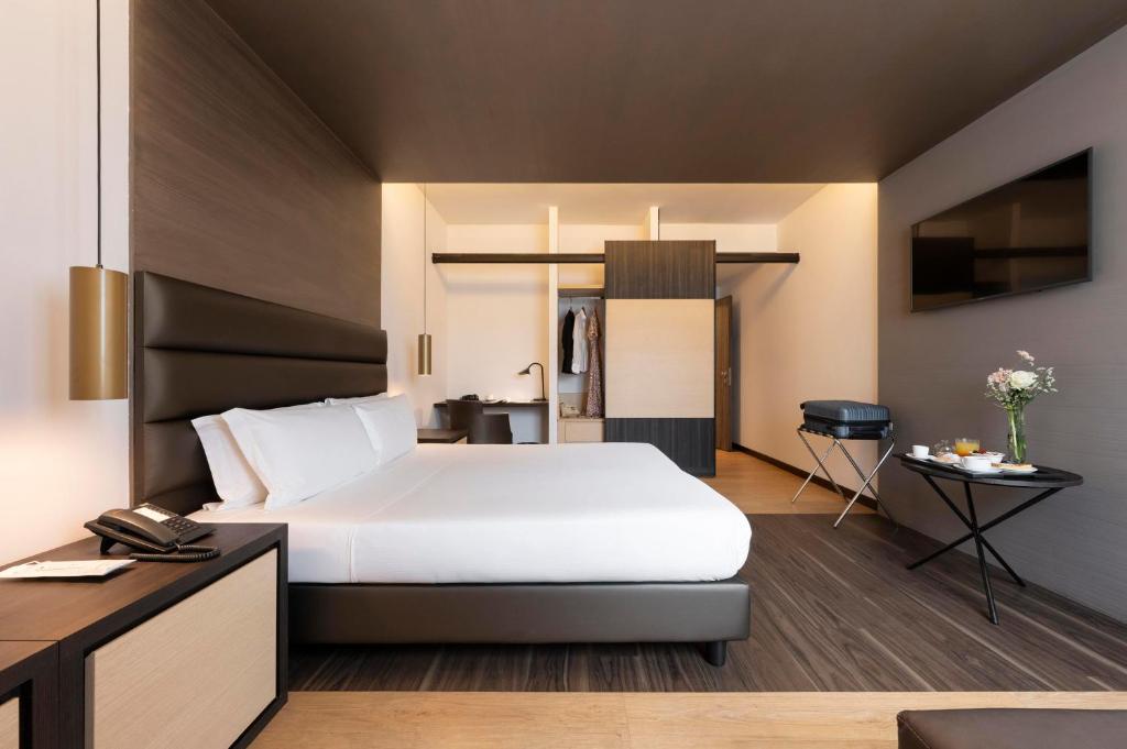 ein Schlafzimmer mit einem großen weißen Bett und einem Schreibtisch in der Unterkunft Warmthotel in Rom