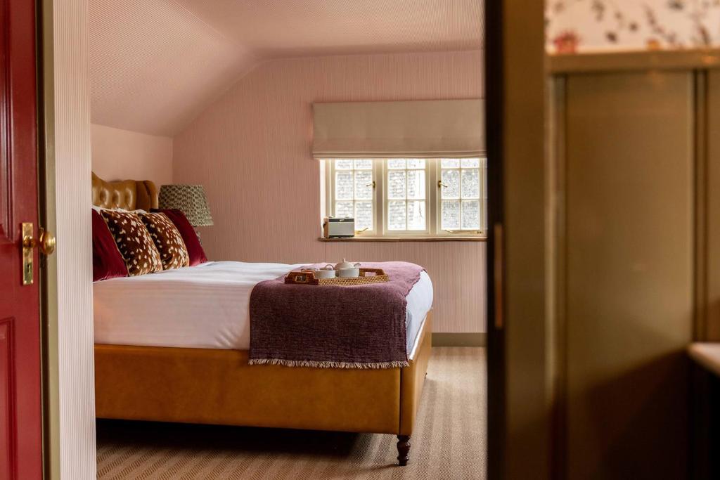 a bedroom with a bed and a window at The Norman Knight in Whichford