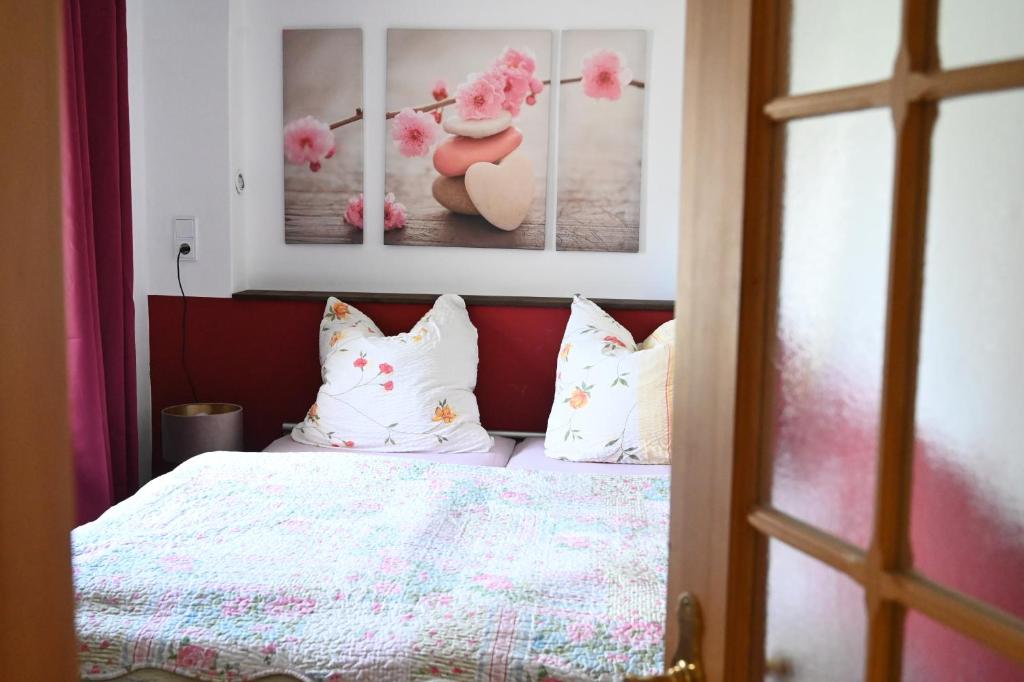 a bedroom with a bed with white pillows and paintings at FEWO RENKEN in Trassenheide