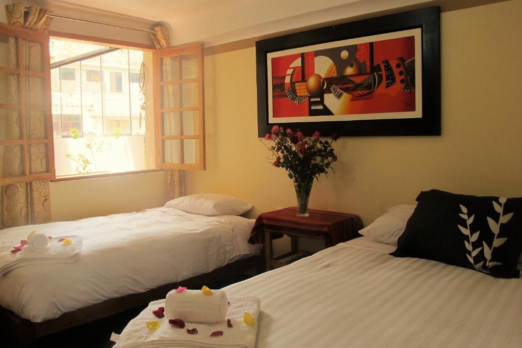 a hotel room with two beds and a window at Tumy house B&B in Ollantaytambo