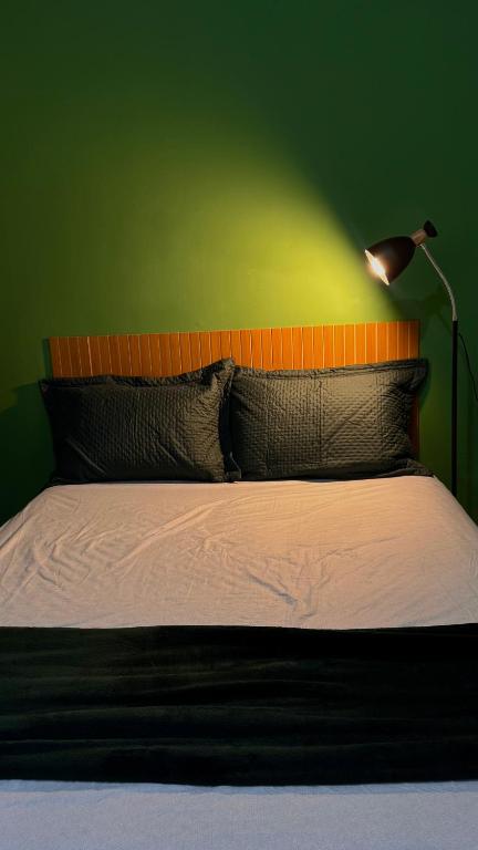 a bedroom with a bed with a green wall at Apartamento próximo ao centro in Primavera do Leste