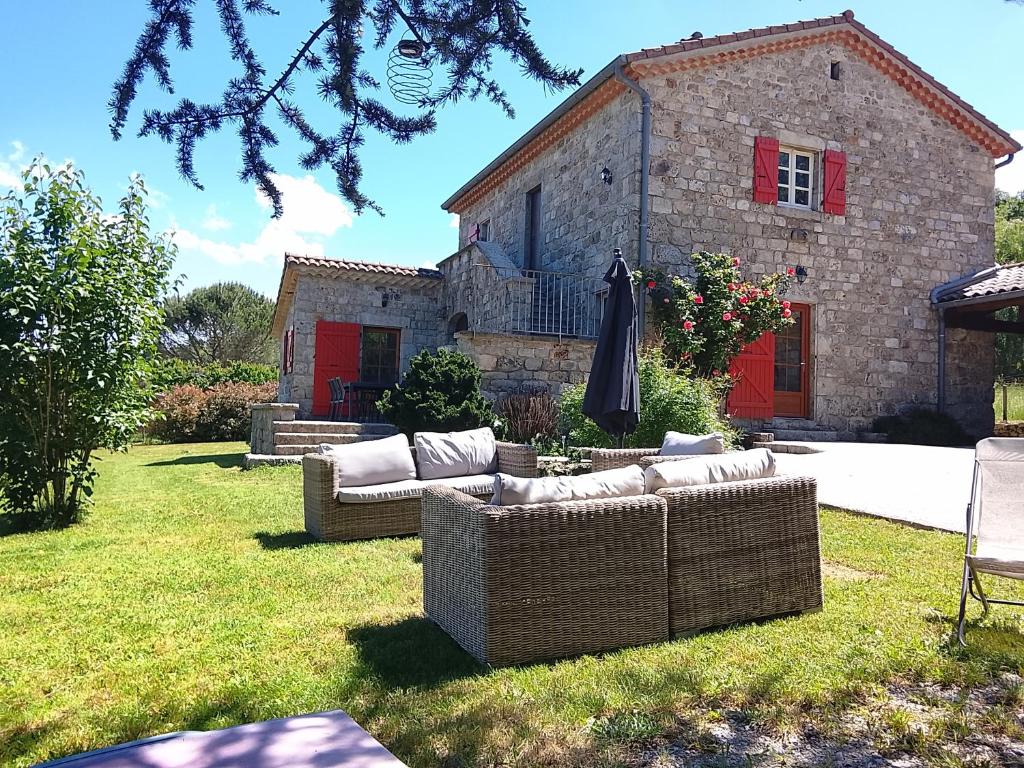 a group of couches sitting in the grass in front of a house at La Maison du Bonheur in Jaujac