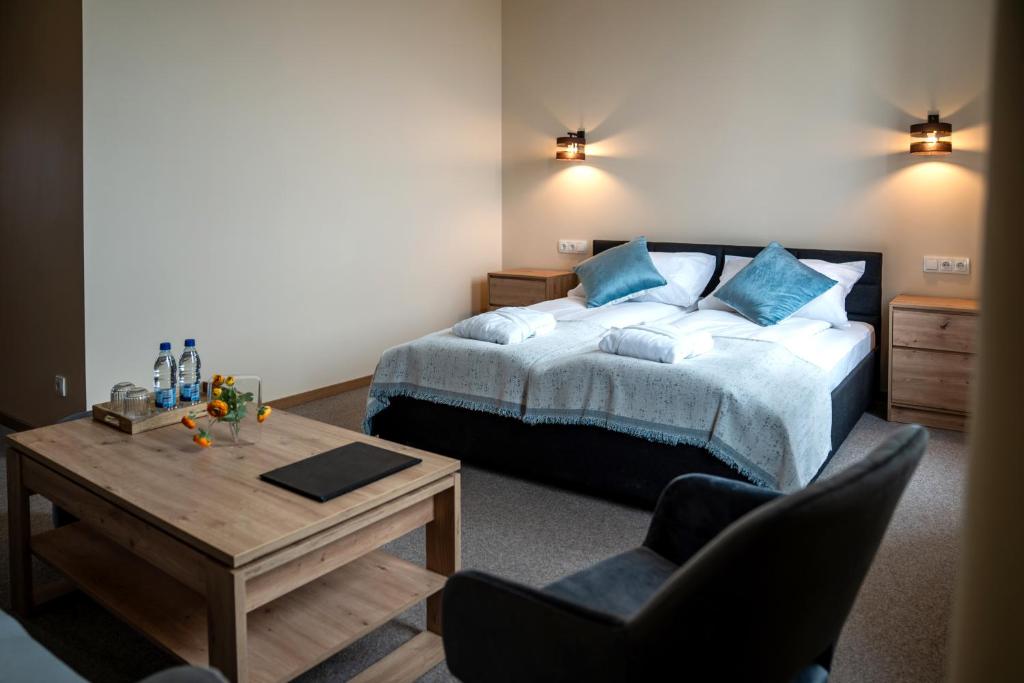 a bedroom with a bed and a table and a chair at Mangal Hotel in Olgina