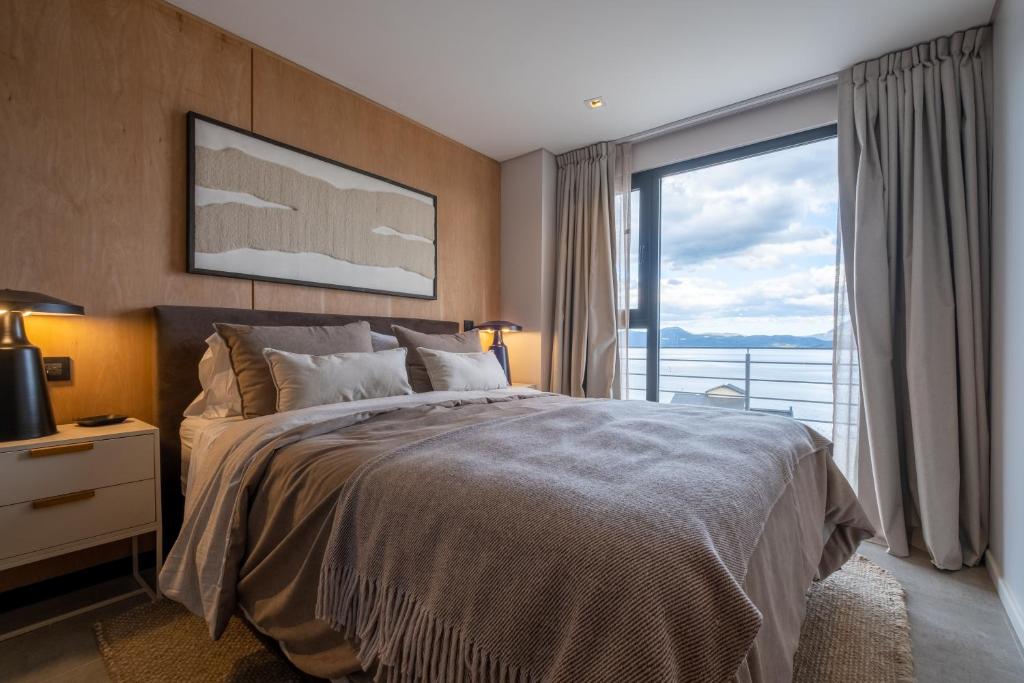a bedroom with a large bed and a large window at Costa Susana Ushuaia in Ushuaia