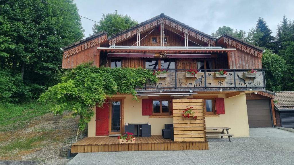 a house with a balcony and a table in front of it at Le montagnard in Lullin