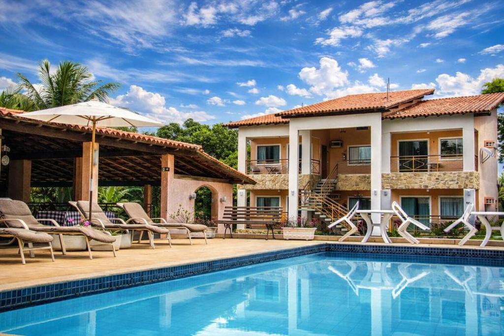 a villa with a swimming pool and a house at Pousada Doce Vida Guarapari in Guarapari