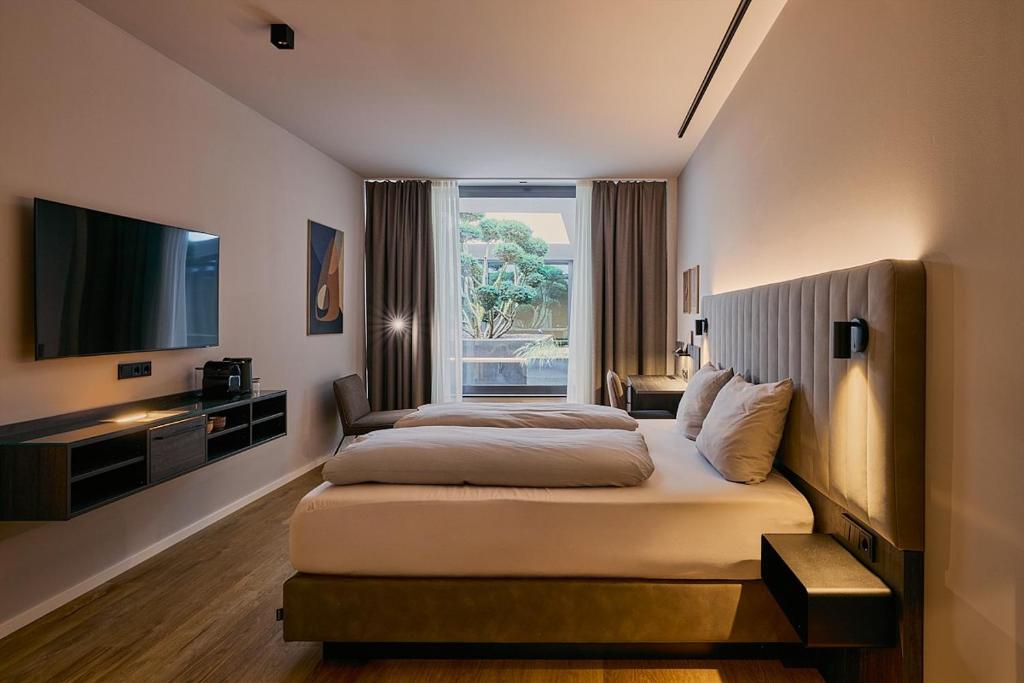ein Hotelzimmer mit Bett und Fernseher in der Unterkunft STORK's NEST in Schrobenhausen