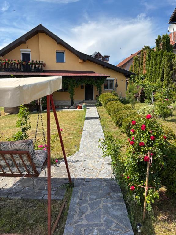 a house with a swing in front of a yard at Apartmani Rada in Zlatibor