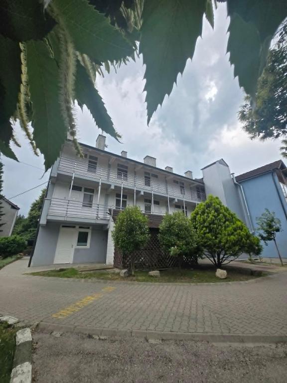 a large white building with trees in front of it at Solar Club Apartman Sopron in Sopron