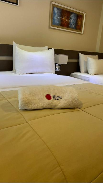 a towel laying on a bed in a hotel room at Hotel Sun in Encarnación