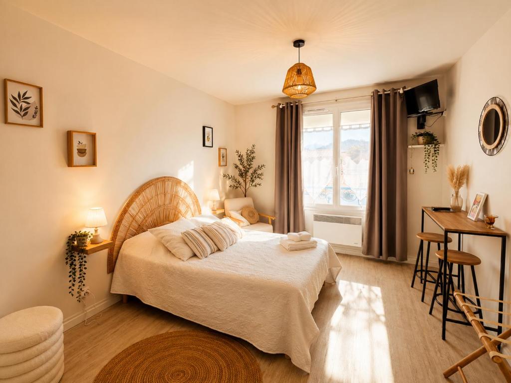 a bedroom with a bed and a desk and a window at Hôtel La Coursive Oléron in Saint-Pierre-dʼOléron