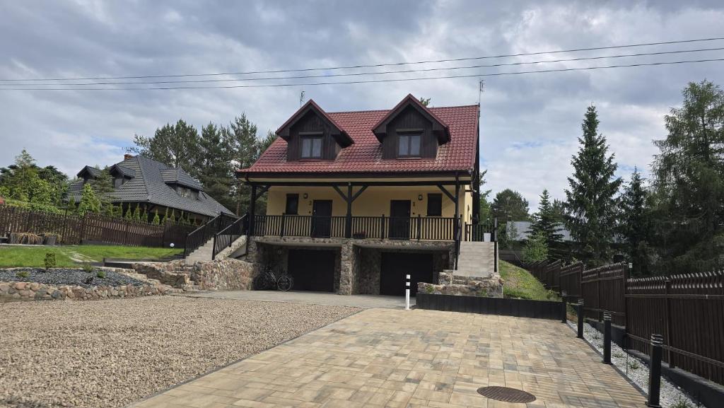 a large yellow house with a red roof at Zaczarowany Gaj in Gaj Grzmięca