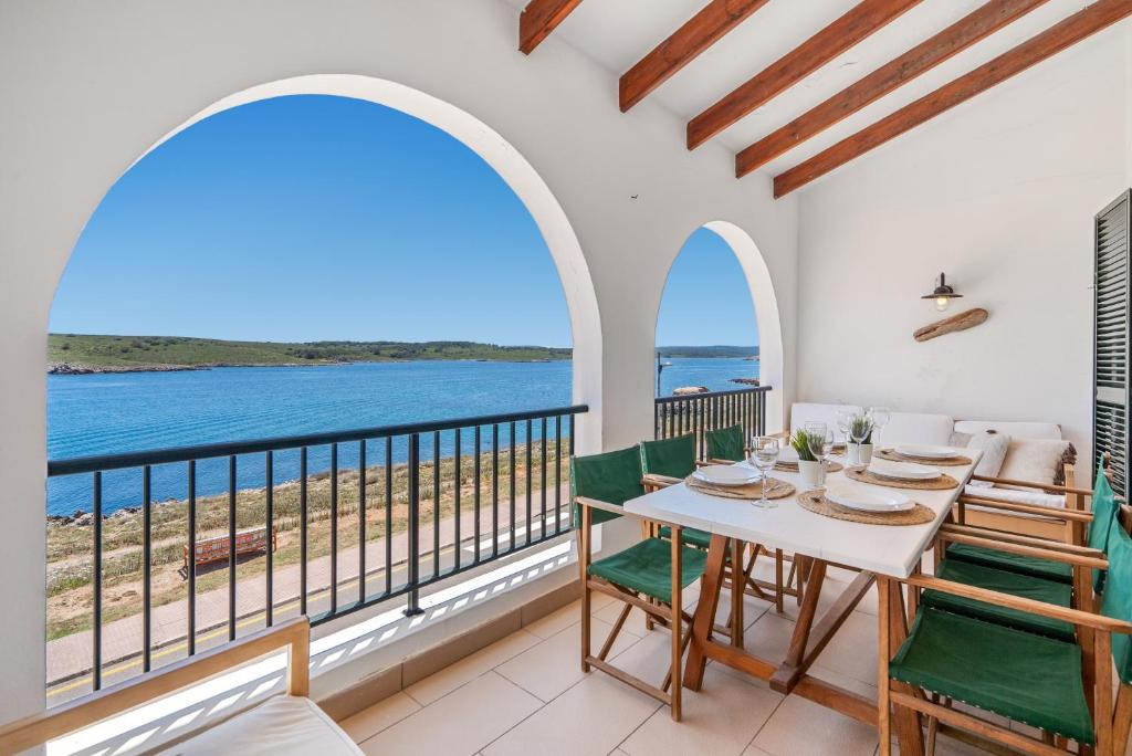 a dining room with a view of the ocean at Tramontana 113 P1 by 3VILLAS in Fornells