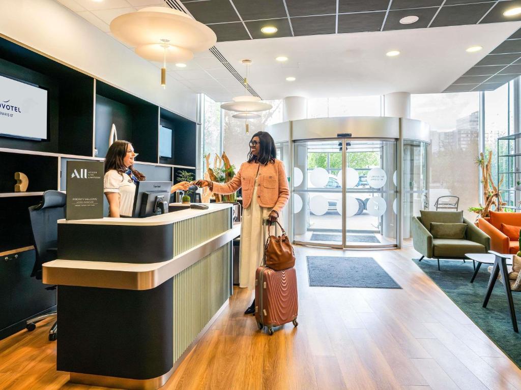 a woman standing at a counter in a store at Novotel Paris 17 in Paris