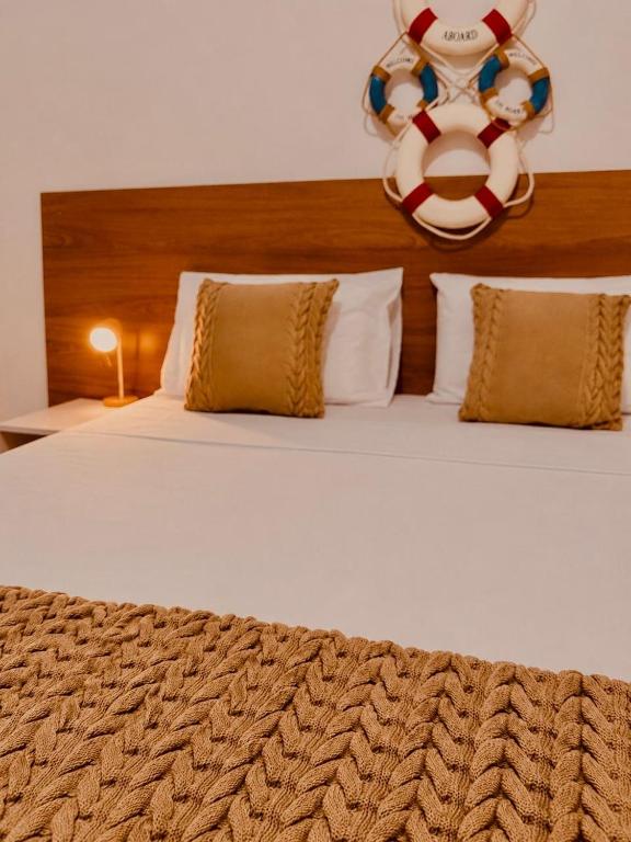 a large white bed with a large headboard and pillows at Pousada Casa da Adriana in Fortaleza