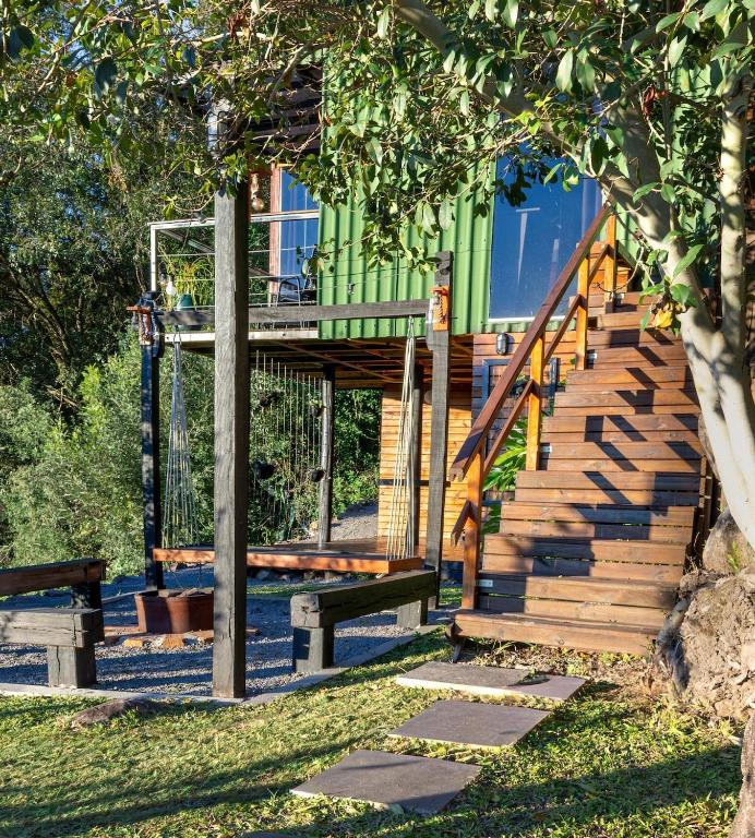a house with stairs and a bench in the grass at Cabana Altavista in Flores da Cunha