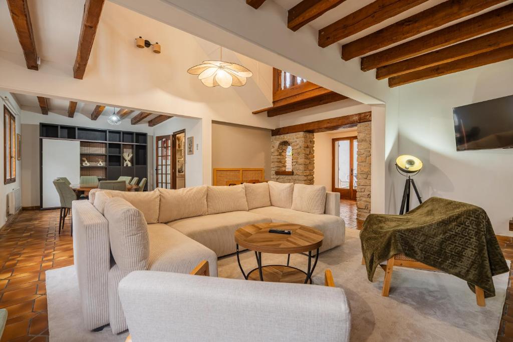 a living room with a couch and a table at Villa Paradis - Grande demeure familiale proche Puy-du-Foυ in Cholet