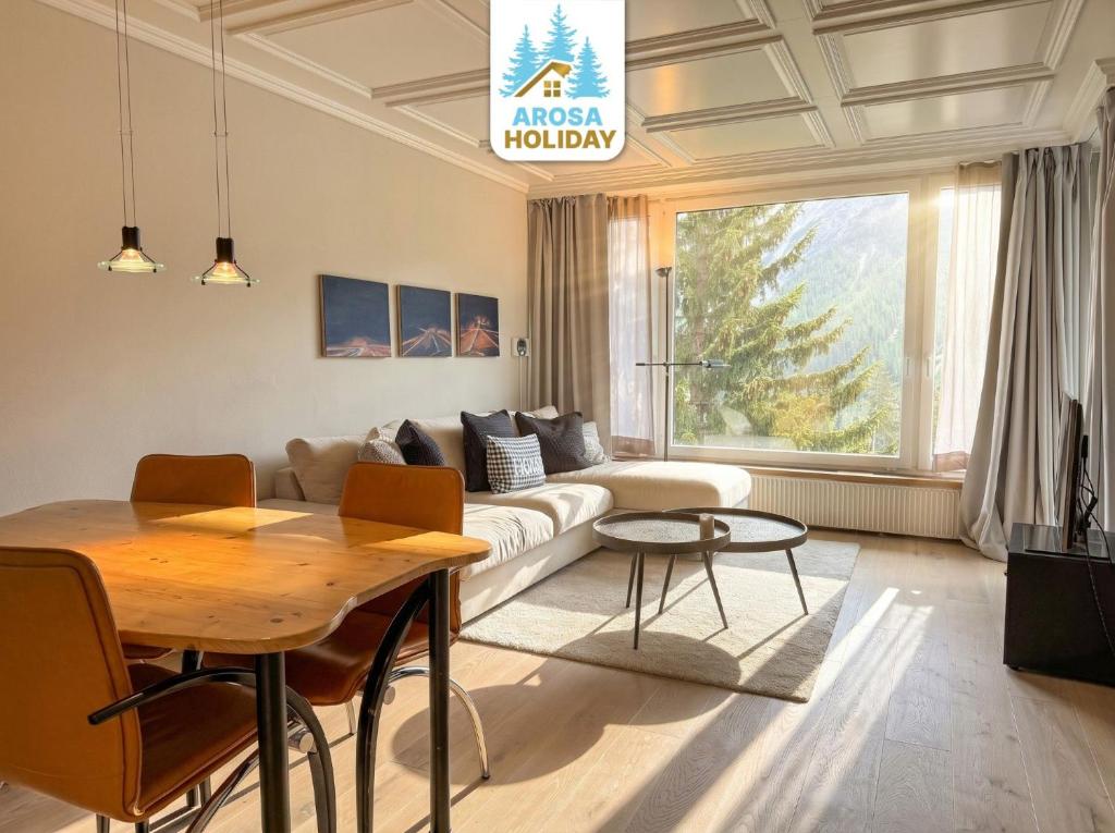 a living room with a couch and a table at Viktoria B19 by Arosa Holiday in Arosa