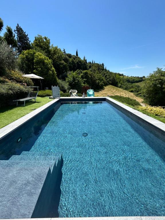 a swimming pool with blue water in a yard at Casa Sunset Hill Bologna in Bologna
