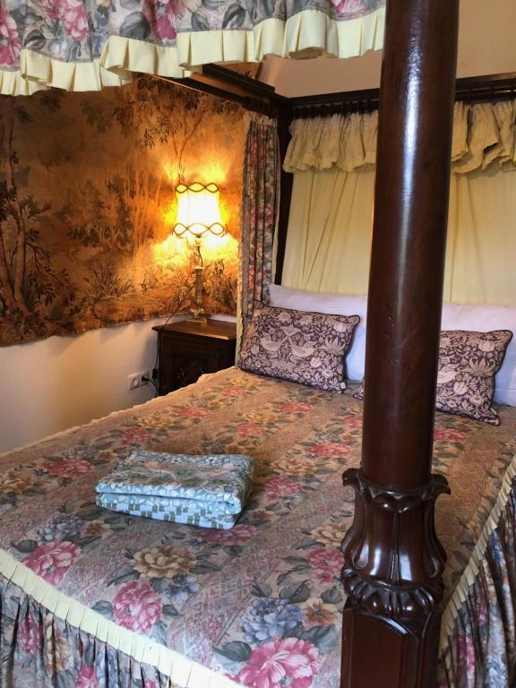 a bedroom with a bed with a wooden post at Old Parish Hall, Waldeck Castle in Beltheim