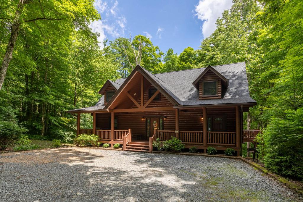 a log cabin in the woods with a driveway at The Feisty Fox in Sugar Mountain