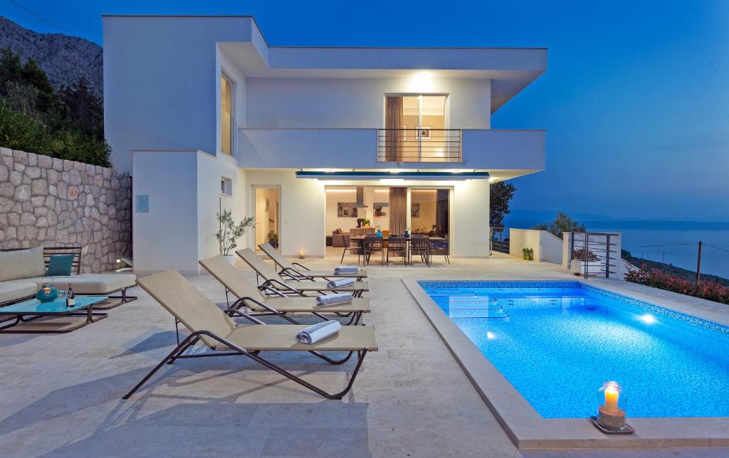 uma villa com piscina à noite em Luxury Villa Mala Podgora em Podgora