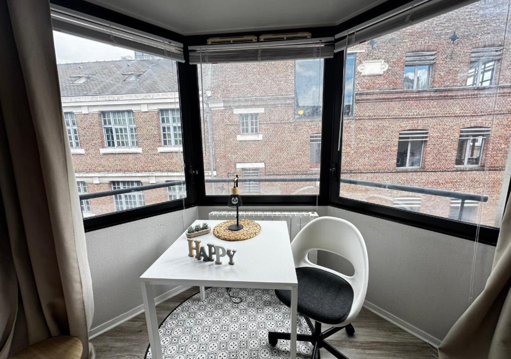 a small white table and chair in a room with a window at Studio Horizon Amiens in Amiens