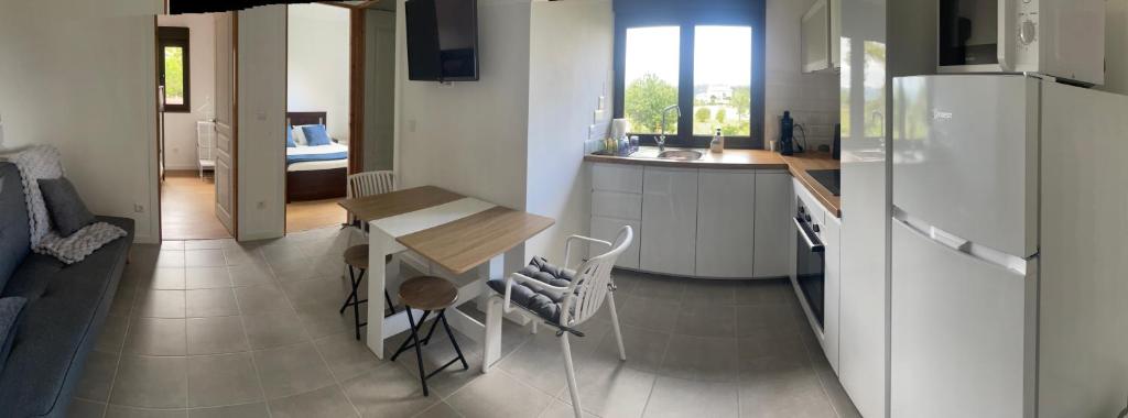 a kitchen with a table and a refrigerator at A Casinha in Ventuzelo