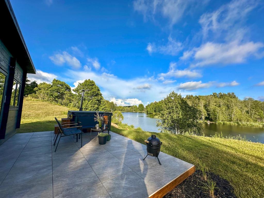 a patio with a view of a river at Black Cat House Radailiai in Radailiai