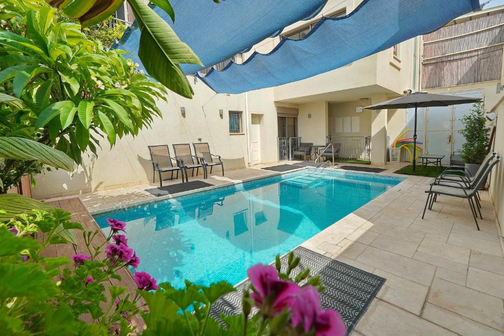 a large swimming pool with chairs and an umbrella at Villa Netofa (Kosher) in Mitspe Netofa