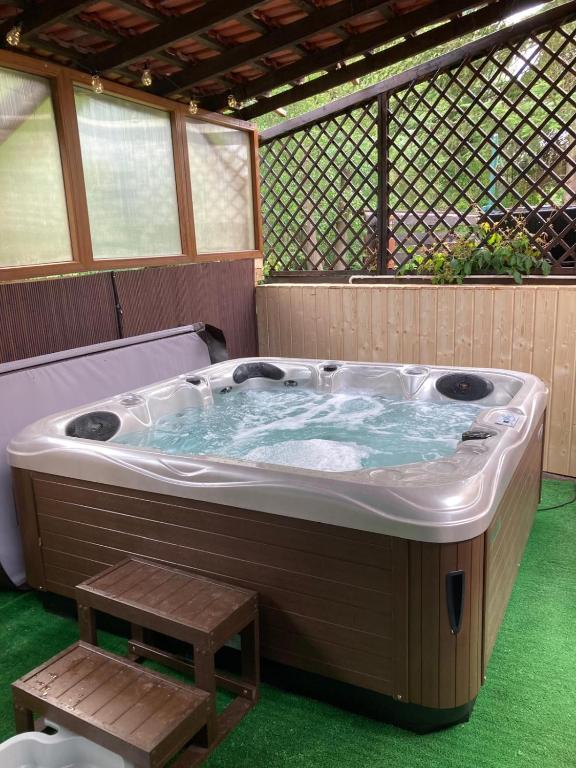 a jacuzzi tub with a wooden bench in a screened at Willa Rudno Nad Jeziorem in Rudno
